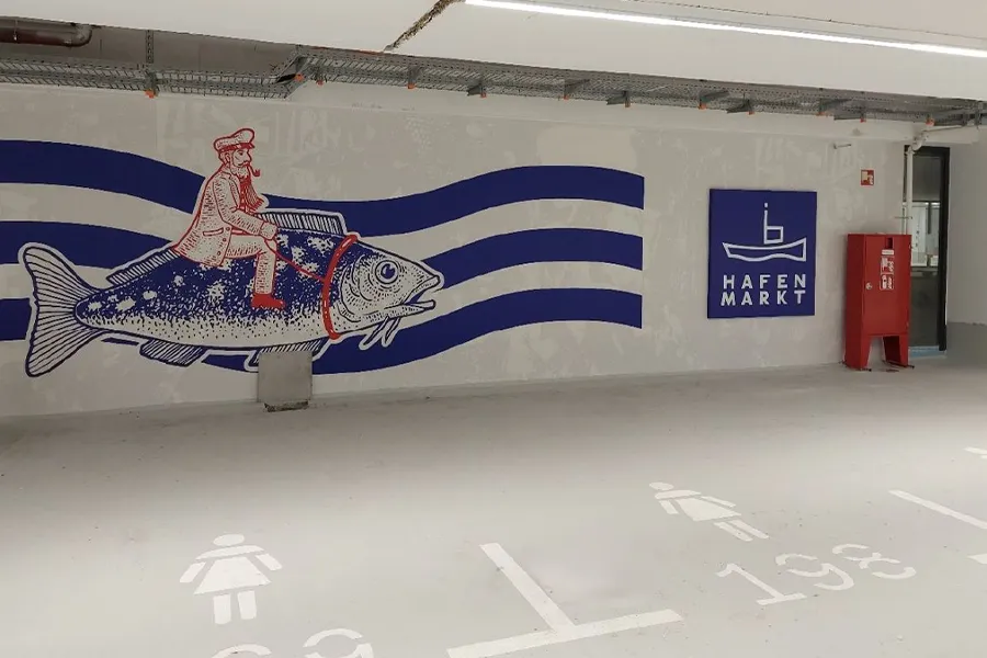 Parkfläche mit Fisch-Graffiti an Wand